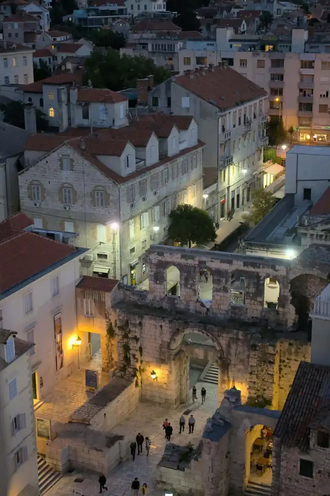 Stone archway opening onto a sunlit medieval lane in Split
