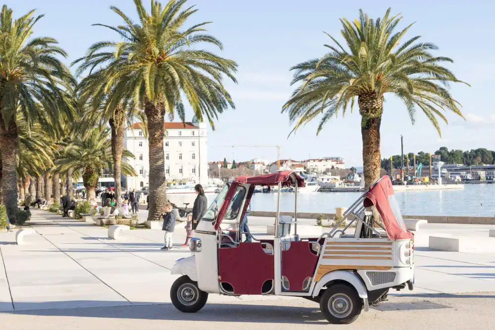 A couple enjoying the sea breeze on a tuk tuk tour of Split