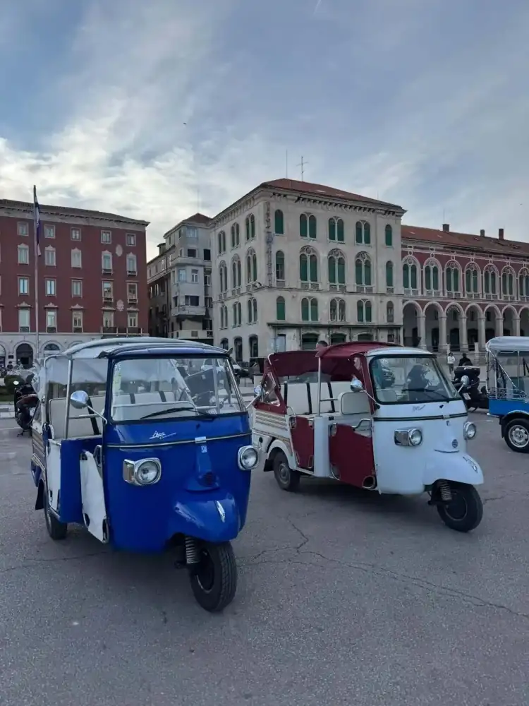 Passengers waving from a tuk tuk in Split's Old Town