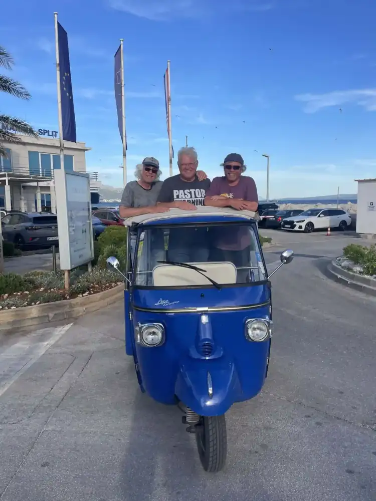 The tuk tuk cruising past the palms of the Riva promenade
