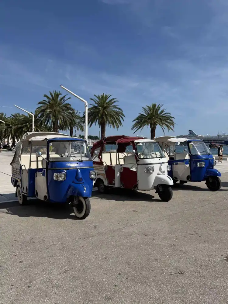 A guide helping guests aboard the retro tuk tuk