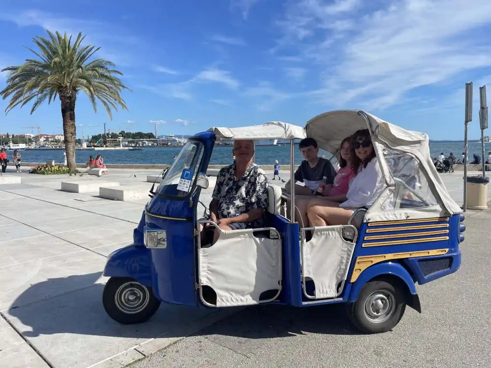 The tuk tuk and its passengers bathed in warm Dalmatian light