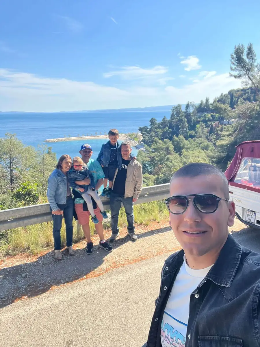 Guests posing at a hilltop lookout with the Adriatic behind them