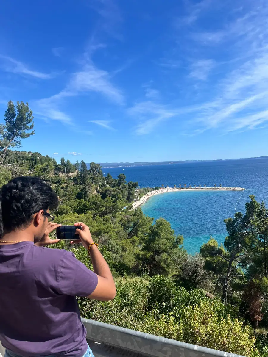 A guest photographing a curving beach below Marjan Hill