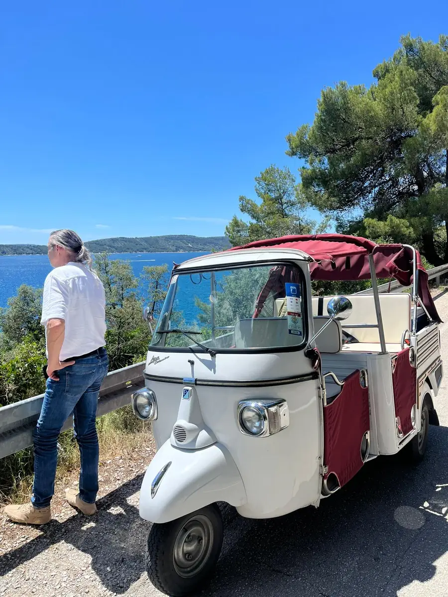 A guest taking in the sea view beside a parked tuk tuk on Marjan